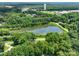 Aerial view showcasing a large pond surrounded by lush green trees and scattered houses in the distance at 132 General Pemberton St, Stanley, NC 28164