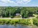 Aerial view of a home with a lush green lawn, surrounded by trees, and a pond in the foreground at 132 General Pemberton St, Stanley, NC 28164