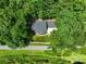 Aerial view of a home with a dark gray roof, set amidst dense green foliage, alongside a road at 132 General Pemberton St, Stanley, NC 28164