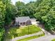 Aerial view of a well-maintained brick home with a lush lawn, surrounded by mature trees at 132 General Pemberton St, Stanley, NC 28164
