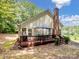 Home's backyard featuring a deck with grill, patio furniture, and serene surroundings at 132 General Pemberton St, Stanley, NC 28164