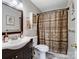 Well-lit bathroom featuring a dark vanity, white toilet, and a decorative shower curtain at 132 General Pemberton St, Stanley, NC 28164