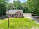 Charming brick home with a manicured lawn, two-car garage, carport, and a welcoming front porch at 132 General Pemberton St, Stanley, NC 28164