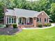 Charming single-story brick home featuring a welcoming front porch, manicured lawn, and classic black shutters at 132 General Pemberton St, Stanley, NC 28164