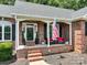 Inviting brick front porch with black shutters, an American flag, and comfortable seating at 132 General Pemberton St, Stanley, NC 28164