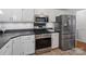 Modern kitchen equipped with stainless steel appliances, sleek dark countertops, and ample storage in white cabinetry at 132 General Pemberton St, Stanley, NC 28164