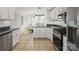 Well-lit kitchen featuring white cabinets, stainless steel appliances, and a view into an adjacent dining area at 132 General Pemberton St, Stanley, NC 28164