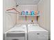 Functional laundry area with white appliances and shelving for storage and organization at 151 Robinson Rd, Gastonia, NC 28056
