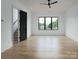 Bright bedroom boasts beautiful hardwood floors, a modern ceiling fan, and a large window with neighborhood views at 1511 Waverly Ave, Charlotte, NC 28203