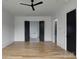 Expansive bedroom features hardwood floors, a modern ceiling fan, and view into the ensuite bathroom with soaking tub at 1511 Waverly Ave, Charlotte, NC 28203
