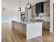 Bright kitchen with a large island, modern pendants, and stainless steel appliances at 1511 Waverly Ave, Charlotte, NC 28203