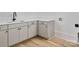 Bright laundry area features shaker cabinets, a quartz countertop, and woodgrain vinyl flooring at 1511 Waverly Ave, Charlotte, NC 28203