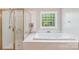Bathroom featuring soaking tub, glass shower, and sunny window above the tub at 15620 Glen Miro Dr, Huntersville, NC 28078