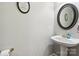 Bathroom featuring a pedestal sink, decorative mirror, and stylish wall decor at 15620 Glen Miro Dr, Huntersville, NC 28078