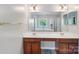 Bathroom featuring double sinks, vanity, and large mirror with modern lighting at 15620 Glen Miro Dr, Huntersville, NC 28078