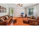 Cozy living room featuring hardwood floors, leather couches, and a ceiling fan at 15620 Glen Miro Dr, Huntersville, NC 28078