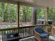 Cozy porch with wicker chair overlooks lush green backyard and wooded scenery at 1713 Arbor Way, Albemarle, NC 28001