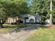 Charming home featuring brick accents, green shutters, and lush, mature landscaping at 1713 Arbor Way, Albemarle, NC 28001