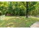 View of the spacious, fenced backyard featuring green grass and mature trees at 203 Nottingham Dr, York, SC 29745