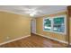 Bright bedroom features hardwood floors, a ceiling fan, and a large window overlooking greenery at 203 Nottingham Dr, York, SC 29745