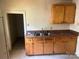 A functional kitchen area with worn countertops, wood cabinetry, and an adjacent room at 213 Maple St, Rock Hill, SC 29730