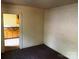 A corner of room shows an open doorway to the kitchen, walls covered with wood planks at 213 Maple St, Rock Hill, SC 29730