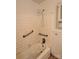 Bathroom with a white tiled shower stall equipped with safety bars and convenient shower wand at 2216 Helen Dr, Gastonia, NC 28054