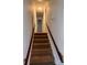 Carpeted staircase leading to the upper level, featuring wooden handrails and bright lighting at 2216 Helen Dr, Gastonia, NC 28054