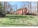 View of the backyard, showing a well-maintained lawn, the brick house, and the back deck at 251 Gleneagles E Rd, Statesville, NC 28625