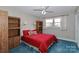 Cozy bedroom with a red quilt, ceiling fan, and built-in bookshelves at 251 Gleneagles E Rd, Statesville, NC 28625