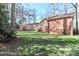 Spacious backyard with a view of the deck, brick house, and mature trees enhancing its appeal at 251 Gleneagles E Rd, Statesville, NC 28625