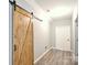 Hallway with barn door and hardwood floors provide a rustic and charming transition space at 265 St Matthews Church Rd, Salisbury, NC 28146