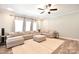 Spacious living room with an area rug, a neutral sectional sofa, a ceiling fan, and multiple windows at 265 St Matthews Church Rd, Salisbury, NC 28146