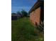 Backyard featuring a brick home exterior, chain link fence and overgrown green grass at 2815 Highland Dr, Lincolnton, NC 28092
