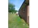 A side view of the backyard featuring a brick house, green grass, and a deck at 2815 Highland Dr, Lincolnton, NC 28092