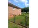 Exterior shot of a brick home and chain link fence surrounded by green grass at 2815 Highland Dr, Lincolnton, NC 28092