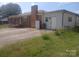Exterior view of a house featuring a brick chimney, white siding, and a spacious driveway at 2815 Highland Dr, Lincolnton, NC 28092