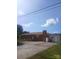 Single-story brick home featuring large chimney, a well-maintained roof, and a paved driveway under a partly cloudy sky at 2815 Highland Dr, Lincolnton, NC 28092