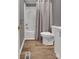 Bathroom features a shower and tub, plus a toilet and vanity with wood look flooring at 329 W Red Cross Rd, Oakboro, NC 28129
