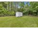 A quaint shed with double doors situated on a verdant, fenced-in yard provides ample storage space at 329 W Red Cross Rd, Oakboro, NC 28129