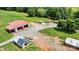 Aerial view of property showcasing a metal building, sheds, and a round pool, set amongst green lawns and trees at 3724 County Home Rd, Conover, NC 28613