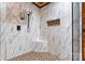 Walk-in shower featuring white marble-look tiling, a built-in shower bench, and black fixtures at 3724 County Home Rd, Conover, NC 28613