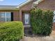 Inviting front entrance with a decorative door, flanked by manicured greenery and black shutters at 3906 Brickfield St, Hickory, NC 28602