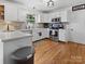 Well-lit kitchen with white cabinets, stainless steel appliances, and hardwood flooring at 3906 Brickfield St, Hickory, NC 28602