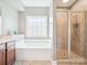 Well-lit bathroom featuring a soaking tub, a window, and a glass-enclosed shower at 4090 Sunset Dr, Rock Hill, SC 29732
