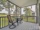 Relaxing screened porch featuring comfortable chairs and scenic views of the green landscape beyond the railing at 4090 Sunset Dr, Rock Hill, SC 29732