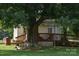 Scenic backyard with a large tree, wooden deck, and landscaped area at 4143 E Maiden Rd, Maiden, NC 28650
