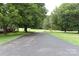 Long paved driveway leading to a home, surrounded by lush green lawns and mature trees at 4143 E Maiden Rd, Maiden, NC 28650