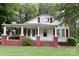 Charming home featuring a covered porch, brick accents, and a well-manicured lawn at 4143 E Maiden Rd, Maiden, NC 28650