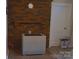 Living room featuring a red brick fireplace, white door, and portable air conditioning unit at 4143 E Maiden Rd, Maiden, NC 28650